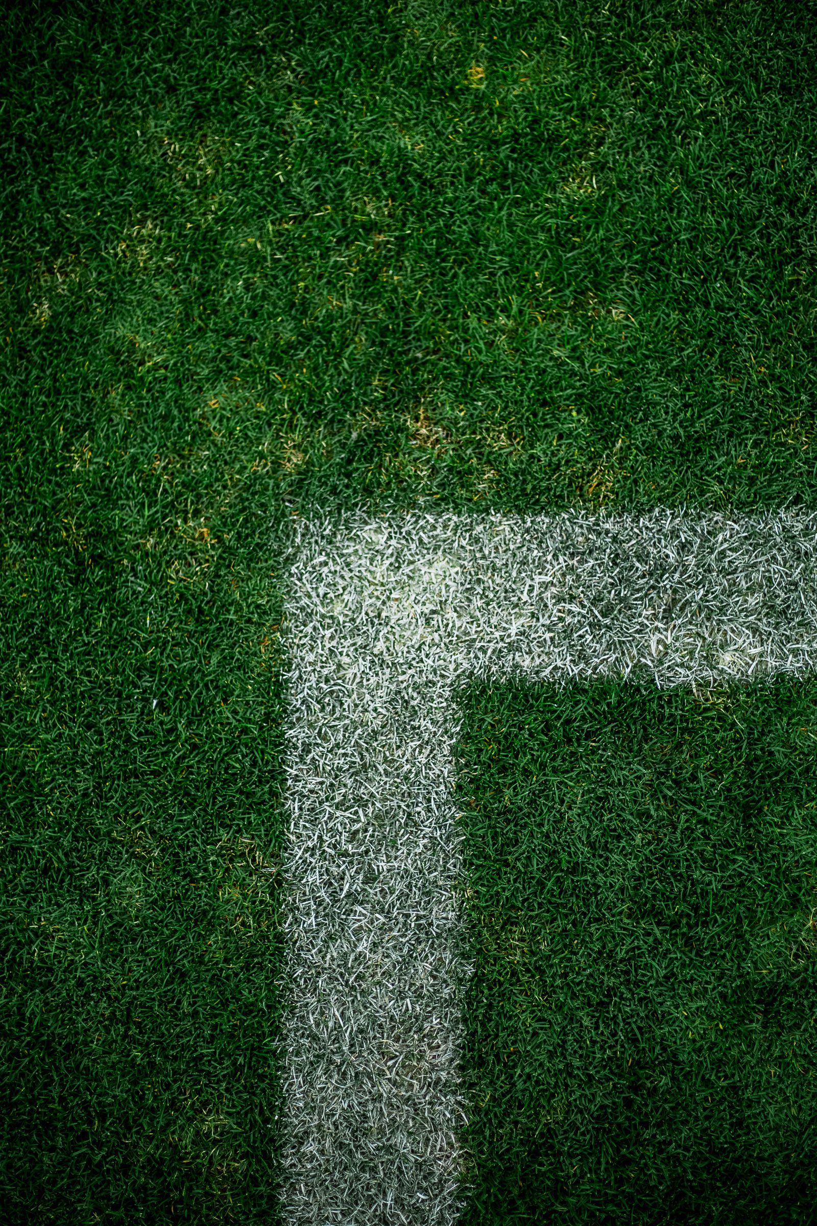 Football field corner with vibrant green turf and white line markings